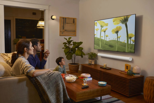 Family watching a movie with a Sonos Playbar for immersive whole home audio